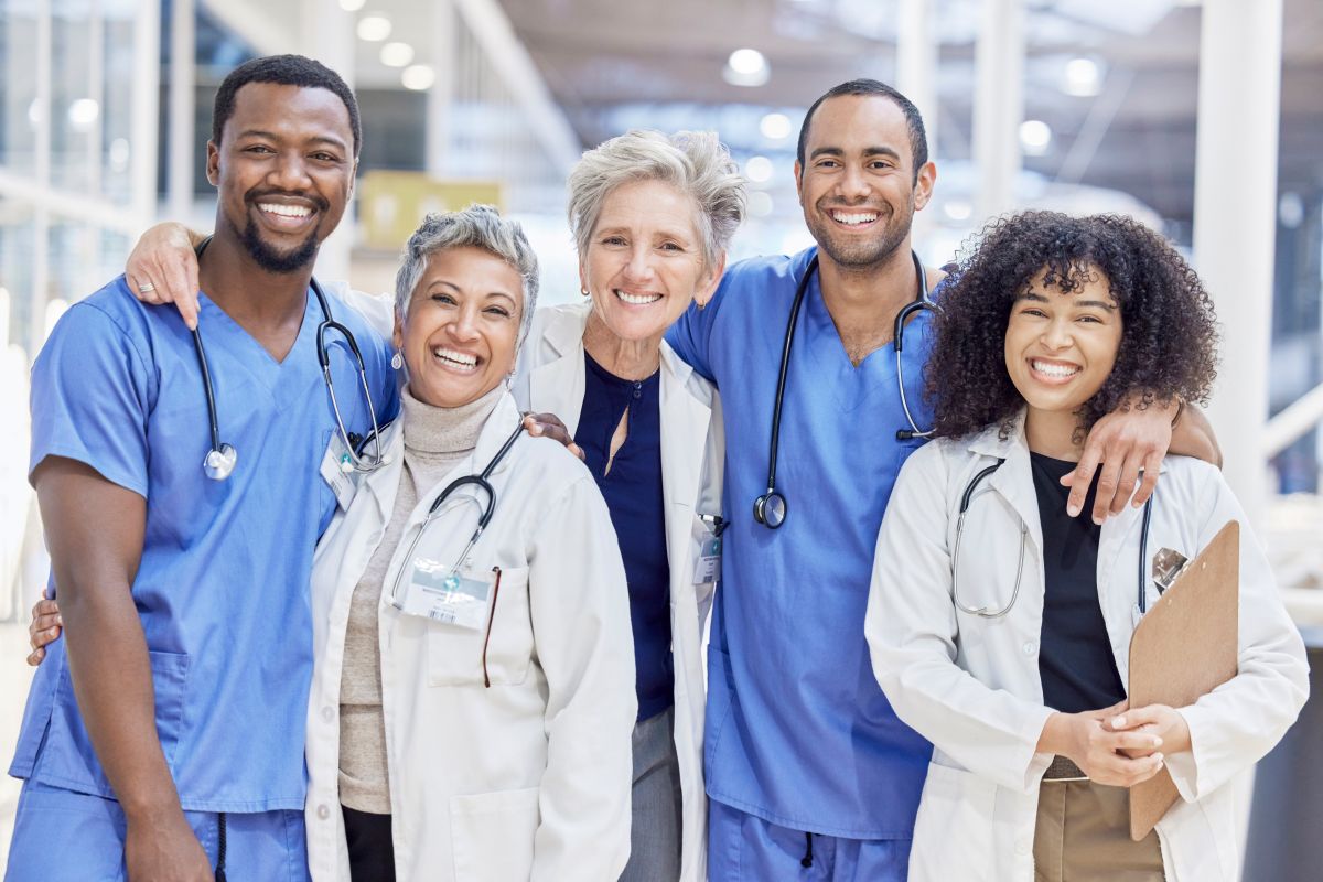 A team of nurses, physicians, and physician assistants smile for the camera.