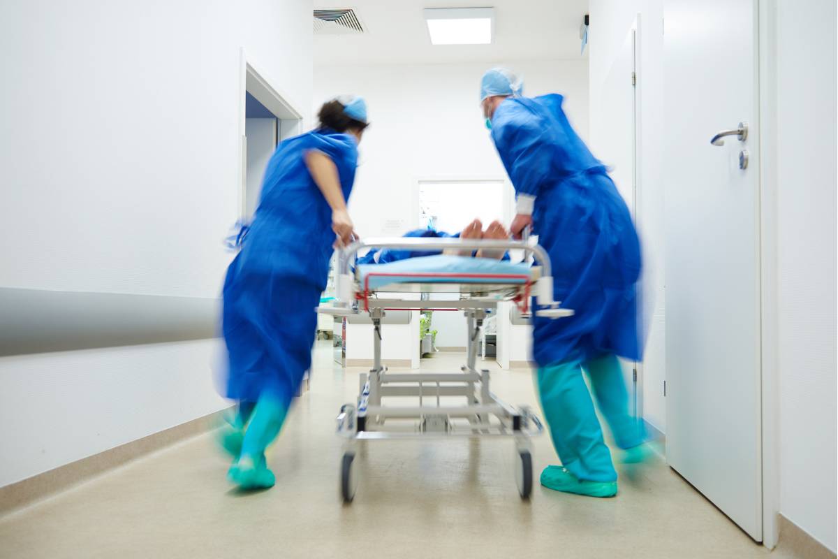 A group of nurses perform rapid triage and then rush a patient to the operating room.