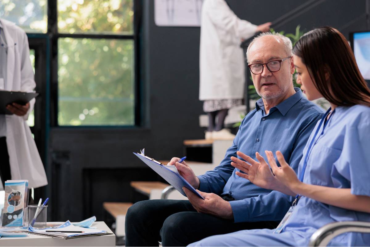 A nurse discusses a patient refusal of treatment form with a patient.