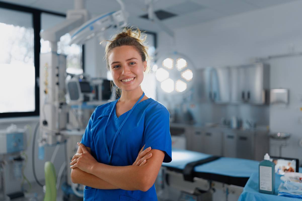 A nurse poses in an operating room while demonstrating resilience in nursing.