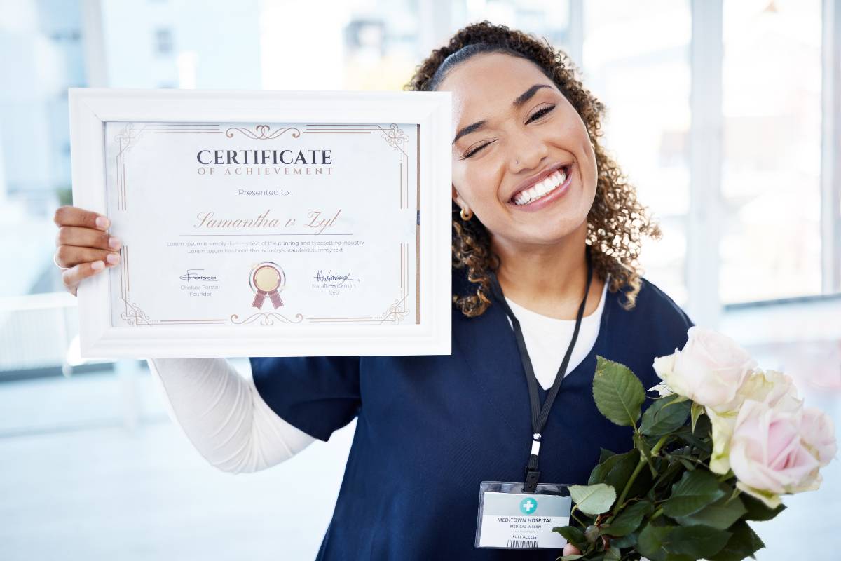 A nurse holds one of the top RN certifications while she poses for a picture.