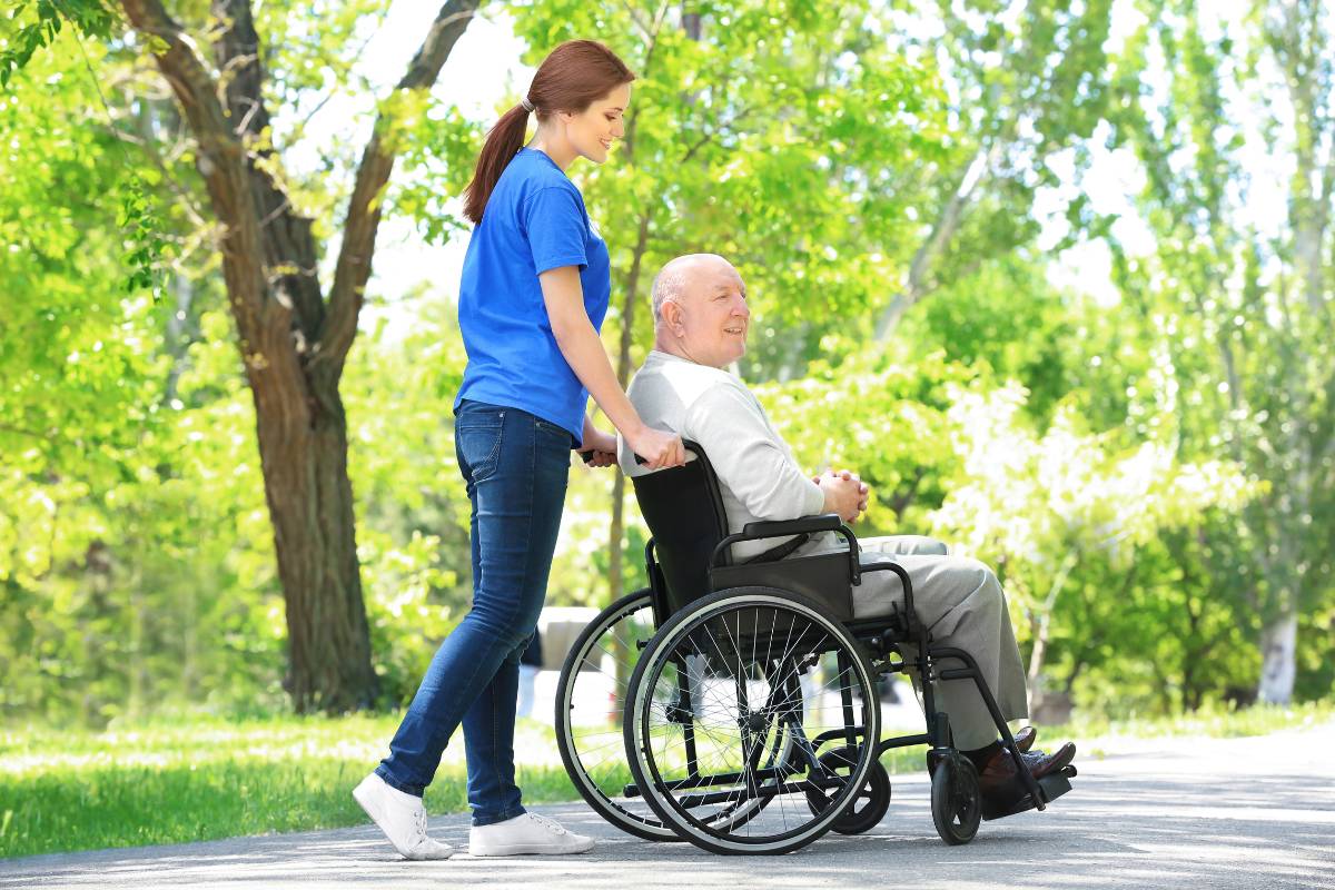A nurse assists an elderly patient during an RN volunteer work opportunity.