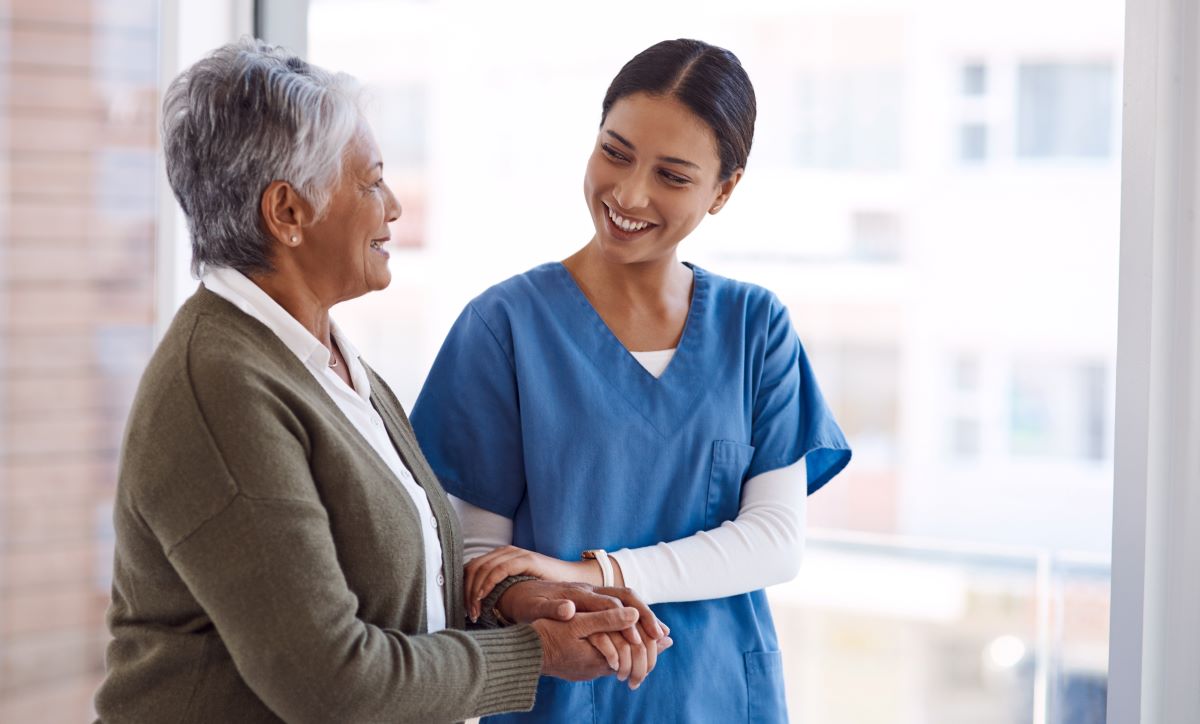 Nurse smiling and holding a patient's arm