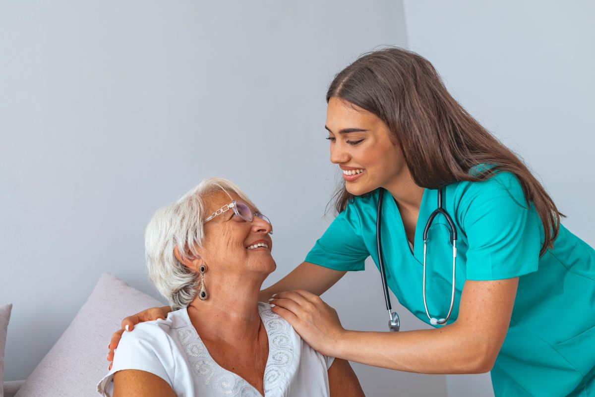 Female STNA comforting a female patient in her room