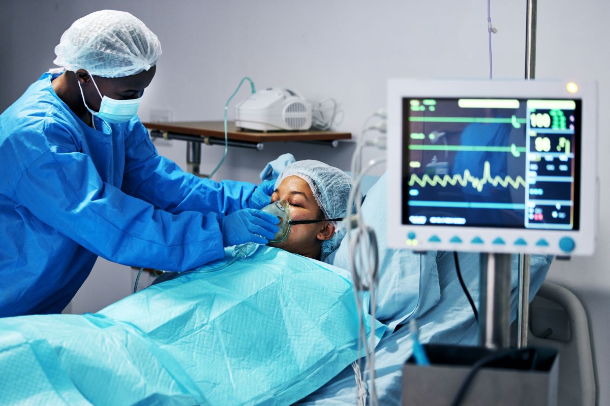 A telemetry nurse fits his patient with an oxygen mask.