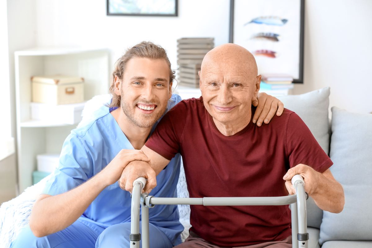 A caregiver assists a patient who is using a walker.