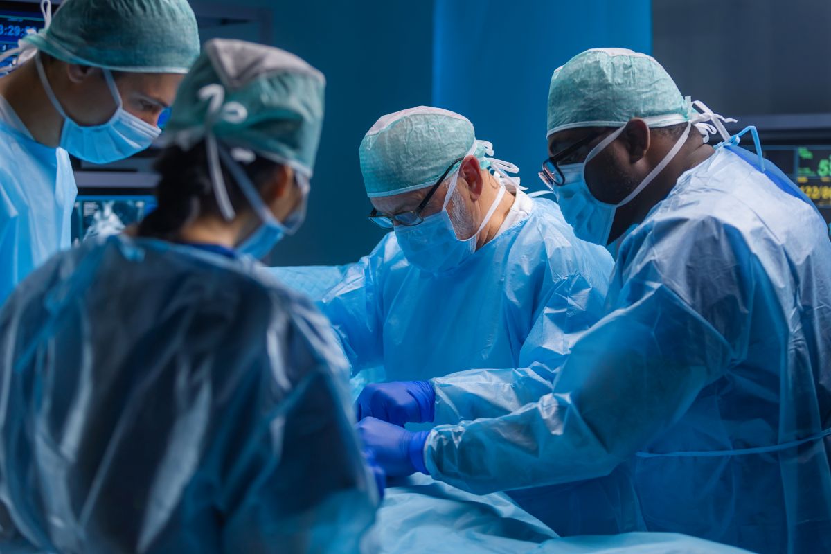 A transplant nurse assists surgeons during a transplant procedure.