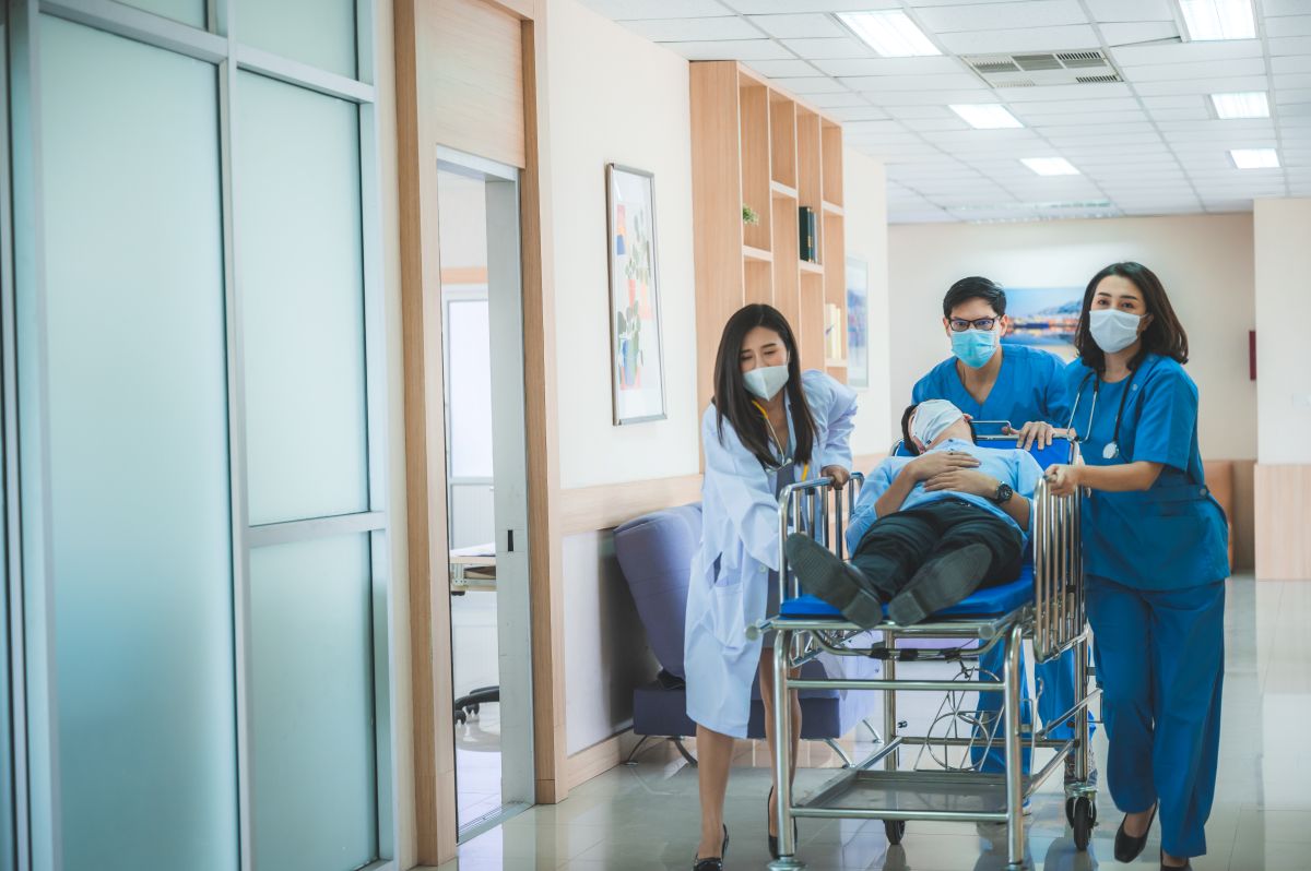Triage nurses transporting a patient in an emergency room
