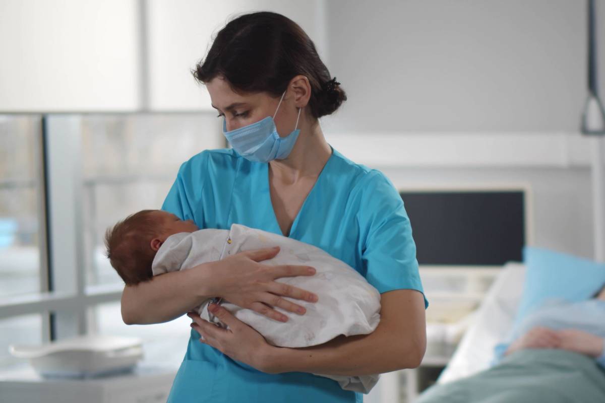 A nursing professional displaying one of the types of nurses that work with babies.