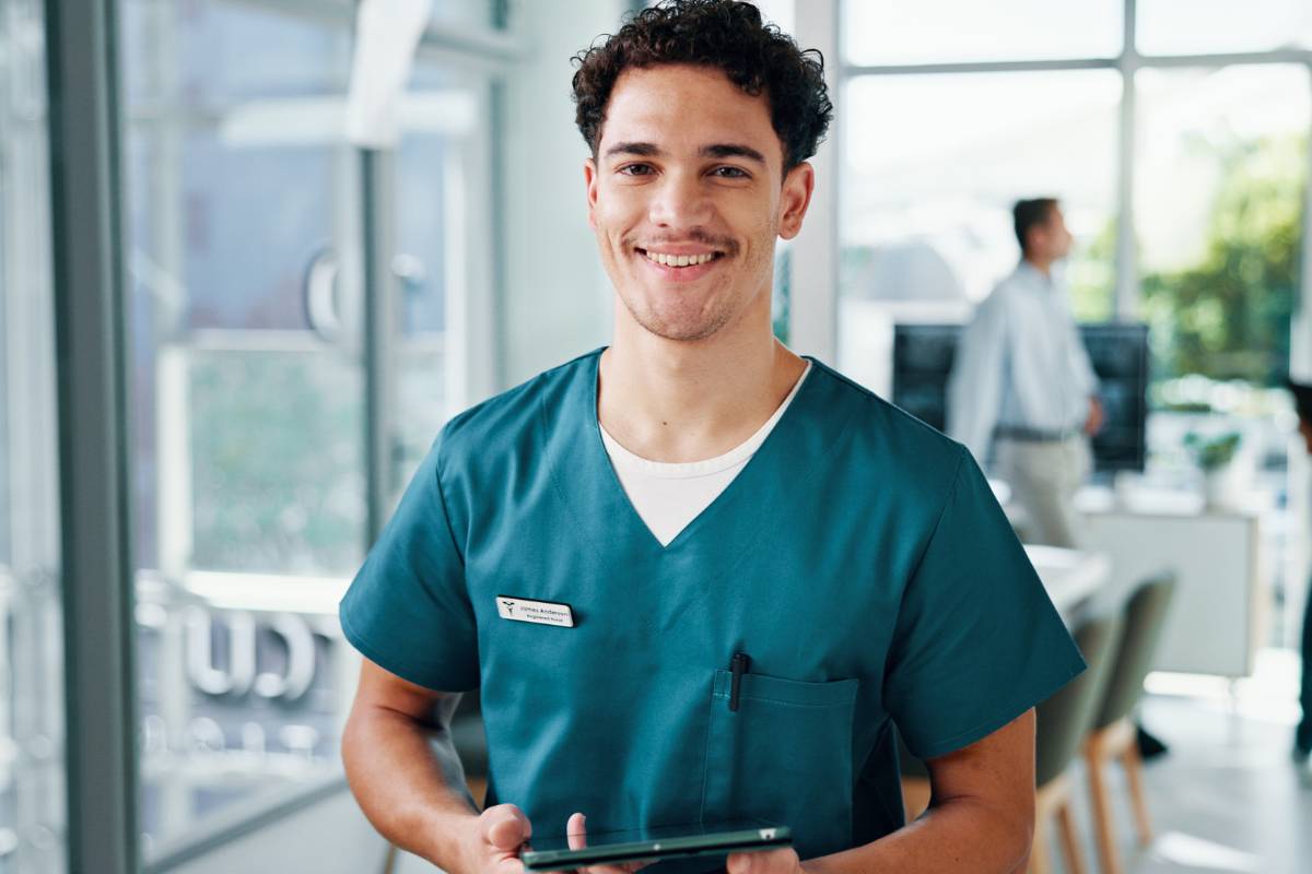 A nurse poses for a photo in a hospital lobby while discussing, Where can registered nurses work?
