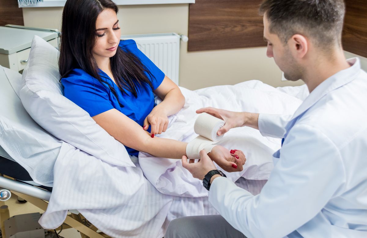 A wound care nurse dresses a patient's arm.